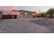 Exterior shot of home with three car garage, gravel driveway, and desert landscaping at 38301 N 15Th Ave, Phoenix, AZ 85086