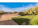 Outdoor arena with well-kept lawns surrounded by vegetation, horse facilities, and a barn with blue sky background at 38301 N 15Th Ave, Phoenix, AZ 85086