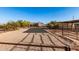 An outdoor horse arena with sandy ground is enclosed by fencing, with shelters, landscaping, and a home in the distance at 38301 N 15Th Ave, Phoenix, AZ 85086