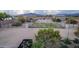 Spacious outdoor arena with green paddock is fenced with a shelter, with mountains in the distance under a bright blue sky at 38301 N 15Th Ave, Phoenix, AZ 85086