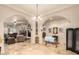 Open-concept living room featuring travertine floors, decorative columns, and a cozy fireplace at 38301 N 15Th Ave, Phoenix, AZ 85086