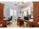 Functional home office with ample desk space, storage cabinets, a window with plantation shutters, and tile flooring at 38301 N 15Th Ave, Phoenix, AZ 85086