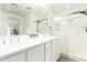 Bright bathroom featuring a double vanity, glass-enclosed shower, and a mirrored wall creating an open feel at 4110 S 58Th Ln, Phoenix, AZ 85043