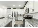 Modern kitchen featuring granite countertops, stainless steel appliances, and white cabinetry at 4110 S 58Th Ln, Phoenix, AZ 85043