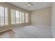 Bedroom with carpet flooring, ceiling fan, and multiple large windows with shutters at 4417 W Lawler Loop, Phoenix, AZ 85083