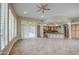 Spacious living room with kitchen view, tile floors, fan, and bright natural light at 4417 W Lawler Loop, Phoenix, AZ 85083