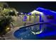 Nighttime scene of a sparkling pool with a fenced yard and string lights at 4546 N 84Th Ln, Phoenix, AZ 85037