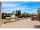 Backyard with outdoor kitchen area, patio seating, and lush greenery surrounding the space at 5045 E Redfield Rd, Scottsdale, AZ 85254