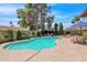 Backyard pool featuring a unique shape, stone dining set, lounge furniture and mature trees at 5045 E Redfield Rd, Scottsdale, AZ 85254