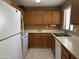 Efficient kitchen with white appliances, wooden cabinets, and ample counter space for preparing delicious meals at 5518 E Lindstrom Ln # 3010, Mesa, AZ 85215