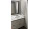 Bathroom vanity featuring a white sink, marble countertop, and gray-framed mirror at 7126 N 19Th Ave # 103, Phoenix, AZ 85021