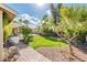 Landscaped backyard featuring desert landscaping, citrus trees, covered patio, and a sparkling pool at 725 E Country Gables Dr, Phoenix, AZ 85022