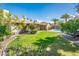 Lush backyard featuring green grass, a sparkling pool, mature landscaping, and covered patio area at 725 E Country Gables Dr, Phoenix, AZ 85022