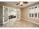 Bedroom with view to living area with tile flooring and a shuttered window at 725 E Country Gables Dr, Phoenix, AZ 85022