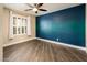 Bright bedroom featuring tile floors, a ceiling fan, a large window with shutters and a bold accent wall at 725 E Country Gables Dr, Phoenix, AZ 85022