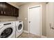 Laundry room with tile floor, cabinets, modern washer and dryer at 725 E Country Gables Dr, Phoenix, AZ 85022