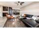 Spacious living room featuring tile and wood flooring, a dark leather sectional sofa, and a glass coffee table at 725 E Country Gables Dr, Phoenix, AZ 85022