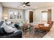 Inviting living room with wood floors, a black leather sectional sofa, and a glass coffee table and ceiling fan at 725 E Country Gables Dr, Phoenix, AZ 85022