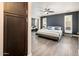 Stylish main bedroom featuring a sleek bed frame, ceiling fan, and mirrored closet doors for ample storage at 725 E Country Gables Dr, Phoenix, AZ 85022