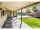 Covered patio area with slate tiles, string lights and view of the backyard and sparkling pool at 725 E Country Gables Dr, Phoenix, AZ 85022