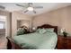 Charming bedroom boasting a wood-framed bed, nightstand, fan, and window with natural light at 7252 N 90Th Ln, Glendale, AZ 85305