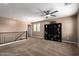 Cozy bonus room featuring plush carpeting, a ceiling fan, and a built-in bookcase at 7252 N 90Th Ln, Glendale, AZ 85305