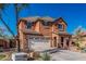 Two-story stucco home with a wide driveway, desert landscaping, tile roof, and a welcoming entrance at 7252 N 90Th Ln, Glendale, AZ 85305