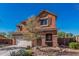 Charming two-story stucco home with desert landscaping, a wide driveway, and a welcoming entrance at 7252 N 90Th Ln, Glendale, AZ 85305