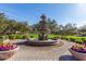 Beautiful multi-tiered fountain with landscaping and flower pots in a well-maintained community at 7252 N 90Th Ln, Glendale, AZ 85305