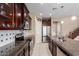 Well-equipped kitchen with dark wood cabinets, stainless steel appliances, and granite countertops with dual basin sink at 7252 N 90Th Ln, Glendale, AZ 85305