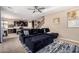 Open-concept living room showcasing plush seating, a modern ceiling fan, and seamless transition to the kitchen at 7252 N 90Th Ln, Glendale, AZ 85305