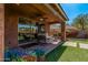 Cozy covered patio area with comfortable seating and a well-manicured lawn for outdoor enjoyment at 7252 N 90Th Ln, Glendale, AZ 85305