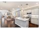 Modern kitchen flows into the living area, featuring white cabinetry, granite countertops, and stainless steel appliances at 7428 W Montgomery Rd, Peoria, AZ 85383