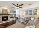 Cozy living room showcases a stacked stone fireplace, a large sectional, and stylish decor, perfect for relaxation at 7428 W Montgomery Rd, Peoria, AZ 85383