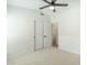 Bright bedroom featuring a ceiling fan, closet, and a view of an adjacent room at 7543 E Keats Ave, Mesa, AZ 85209