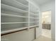 Bright walk-in closet with custom white shelves and a view into the luxurious bathroom at 7543 E Keats Ave, Mesa, AZ 85209