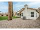 Rear exterior view of a home featuring a landscaped yard with mature trees and covered patio at 7543 E Keats Ave, Mesa, AZ 85209