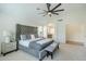 Main bedroom featuring a ceiling fan, gray headboard, and en-suite bathroom access at 7543 E Keats Ave, Mesa, AZ 85209