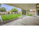 Covered patio view showcasing lush lawn, mature trees and a block fence, offering privacy at 7543 E Keats Ave, Mesa, AZ 85209