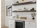 Stylish bar area featuring floating wood shelves, white cabinetry, quartz countertop, and a built-in wine fridge at 8405 N Via Mia --, Scottsdale, AZ 85258