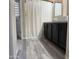 Bright bathroom featuring gray wood-look floors and a shower with a neutral striped curtain at 872 W Desert Sky Dr, San Tan Valley, AZ 85143