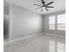 A gray-toned bedroom with a modern ceiling fan, two windows, and sleek tile floors at 8836 S 165Th Ave, Goodyear, AZ 85338