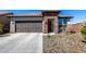 Charming single-story home featuring a stone facade, a two-car garage, and low-maintenance desert landscaping at 8836 S 165Th Ave, Goodyear, AZ 85338