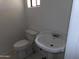 Small bathroom with a toilet and sink, providing basic amenities in a compact space at 8846 N 3Rd St, Phoenix, AZ 85020