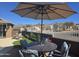 Patio dining set with an umbrella and lounge chairs overlooking a lush backyard at 8965 E Red Mountain Ln, Gold Canyon, AZ 85118