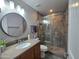 Modern bathroom featuring a stone vanity, round mirror and tiled shower with sliding glass door at 8965 E Red Mountain Ln, Gold Canyon, AZ 85118