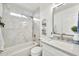 Well-lit bathroom with a shower-tub combo, white marble tile, and modern fixtures, including a frameless mirror at 9138 E Emerald Dr, Sun Lakes, AZ 85248