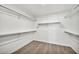 Walk-in closet with hardwood floors and white walls featuring multiple rows of rods for maximum storage at 9138 E Emerald Dr, Sun Lakes, AZ 85248