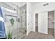 Modern shower with glass enclosure, gray tile, and dual shower heads, leading to a walk-in closet at 9138 E Emerald Dr, Sun Lakes, AZ 85248