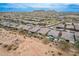 A high angle view of an expansive community with similar homes and serene desert landscape at 9302 W White Feather Ln, Peoria, AZ 85383